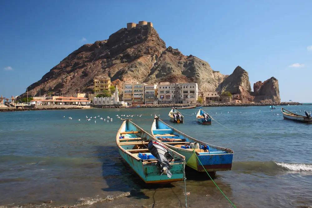 Small motorboats float on the water in the harbor of Aden for a piece titled Is Yemen Safe to Visit