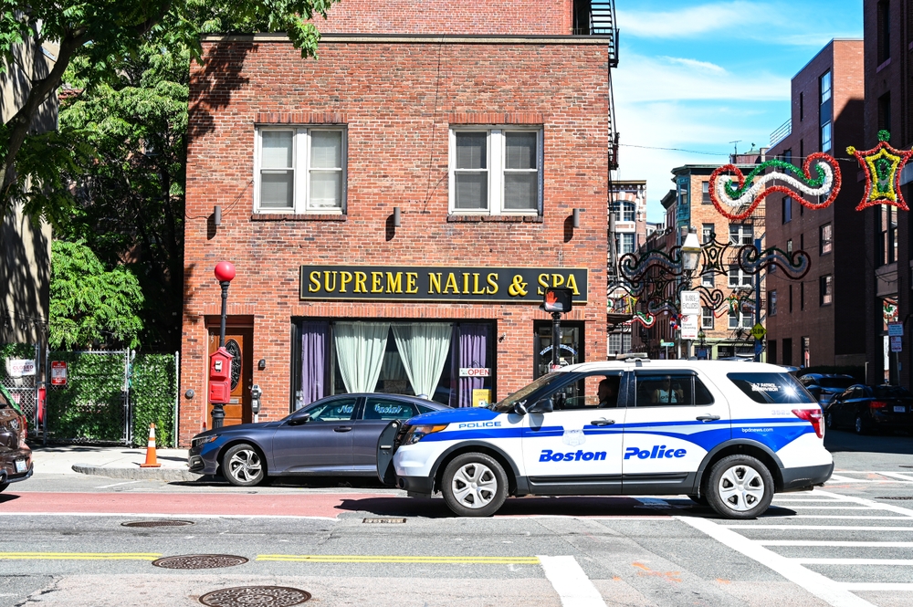 Image of a police car outside a nail salon in a historic intersection for a piece on whether nor not Boston is safe to visit