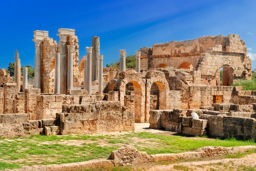 Leptis Magna Roman ruins and archaeological UNESCO site with blue skies during the cheapest time to visit Libya