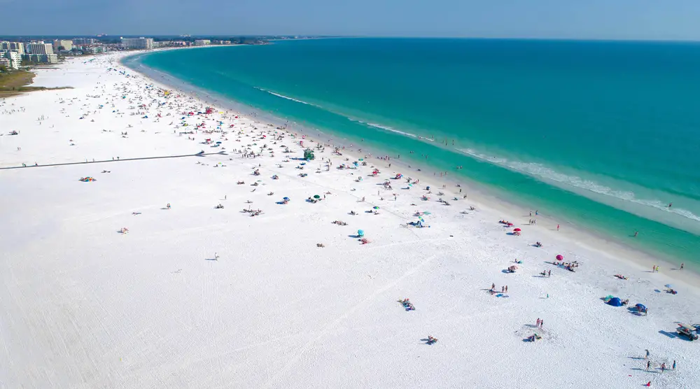 Siesta Key Beach in Sarasota Florida is ranked as one of the top beaches in the USA, shown from above with tourists on the shore