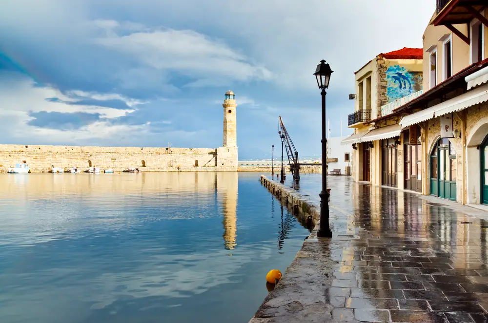 Στη φωτογραφία κατά τη διάρκεια της καλύτερης συνολικής εποχής για να επισκεφθείτε την Κρήτη, ένα μοναστήρι βρίσκεται δίπλα σε νερό ακόμα σαν ποτήρι