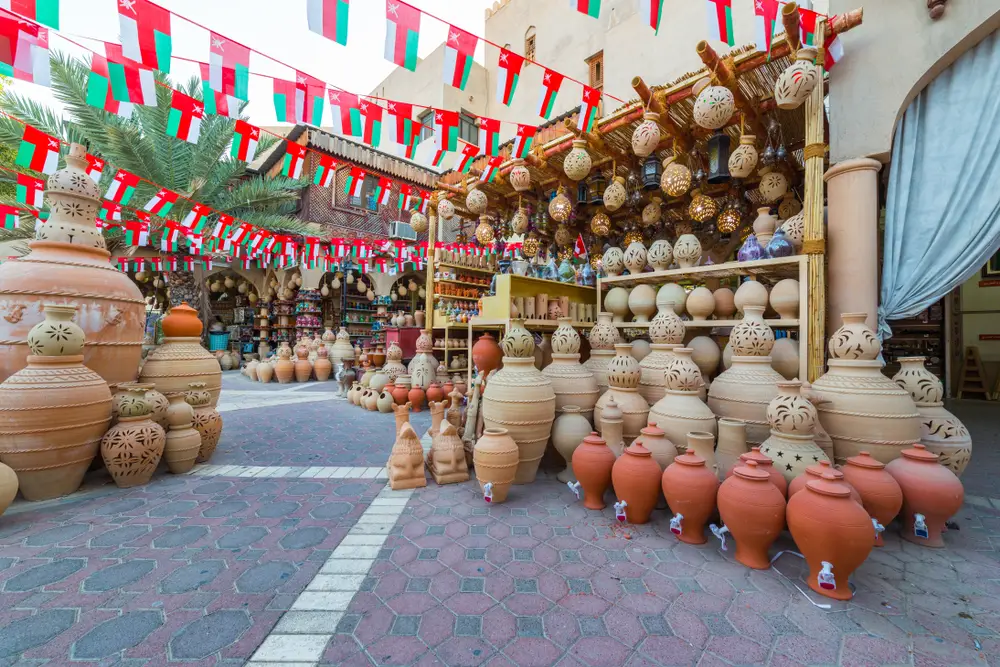 Market in the Souq of Nizwa, pictured for a piece on whether or not Oman is safe to visit, with clay pottery and lamps outside of the market