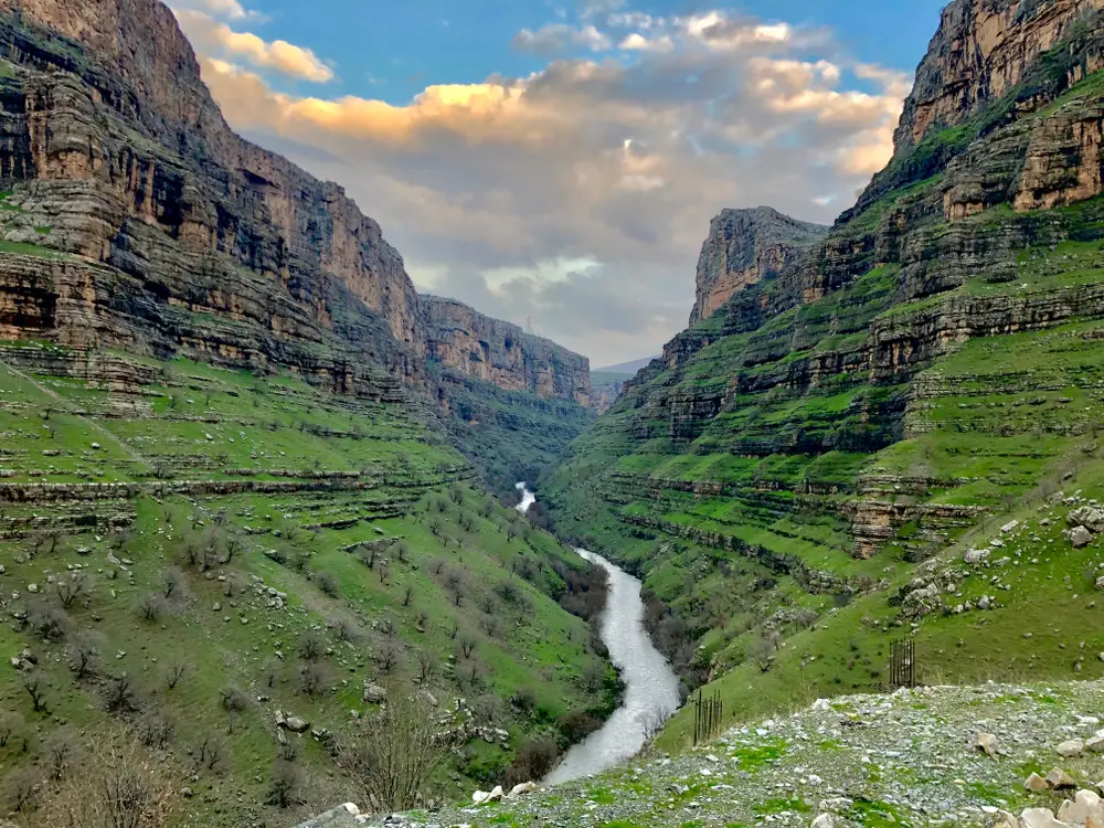 Rawanduz mountain area in Iraq, one of the country's most safe places to visit, pictured with a stream running through the tall mountains on either side