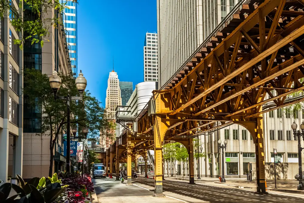 The famous Loop (downtown) pictured from under the bridge between skyscrapers as a featured area to stay in Chicago