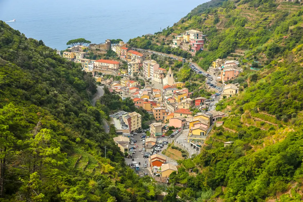 Aerial view of Riomaggiore nestled between green hills during the least busy time to visit Cinque Terre