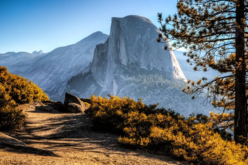 Half Dome as seen from an elevated hiking trail on the side of a mountain for a piece titled Is Yosemite Safe to Visit