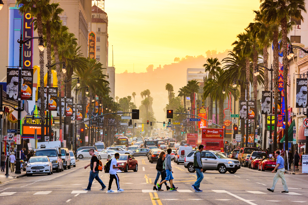 People walking along the street on Hollywood Boulevard pictured on a hazy day during one of the best times to visit Los Angeles