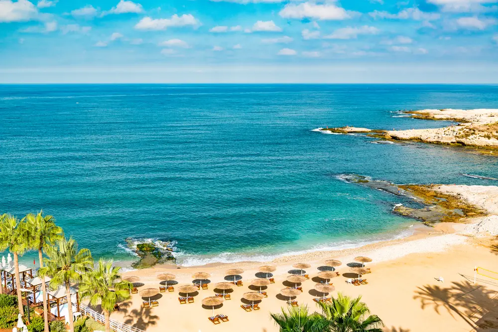 Aerial view of a private beach in front of a Beirut resort in Raouche on a beautiful day with umbrellas on the shore during the best time to visit Lebanon