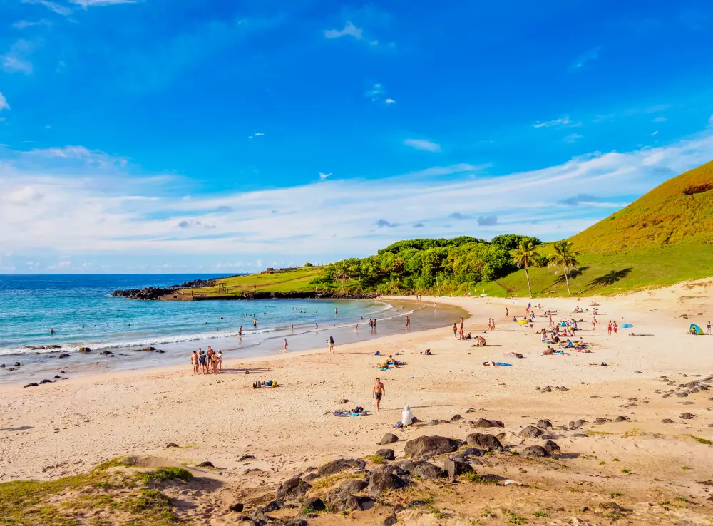 Gorgeous cresent-shaped Anakena Beach pictured below a deep blue sky during the best time to visit Easter Island