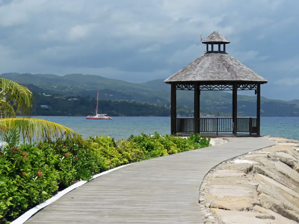 Gorgeous gazebo in Montego Bay for a piece on whether or not it's safe to visit with a cloudy sky above the sailboat on the water