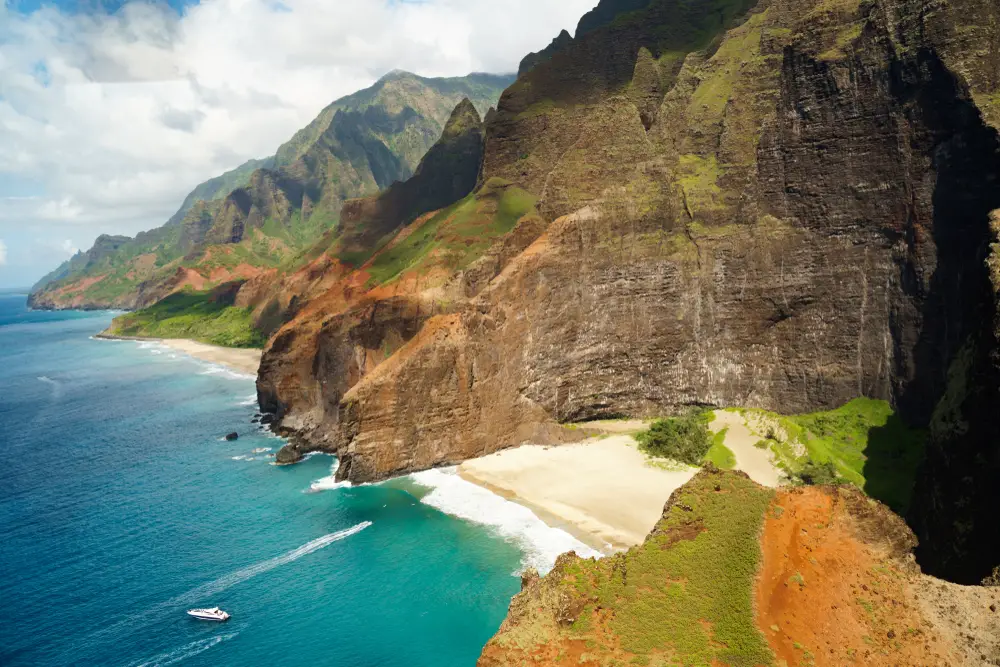 Aerial view of a secluded beach nestled within the cliffs of the Na Pali Coast in Kauai