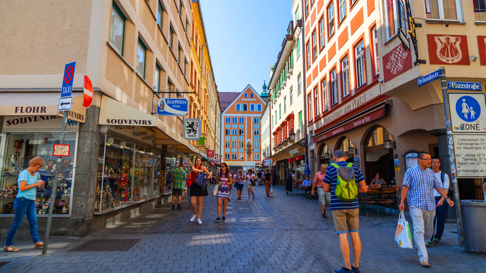 People walking around the tourist area of Alstadt, one of the best areas to stay in Munich, on a clear day with few people on the street