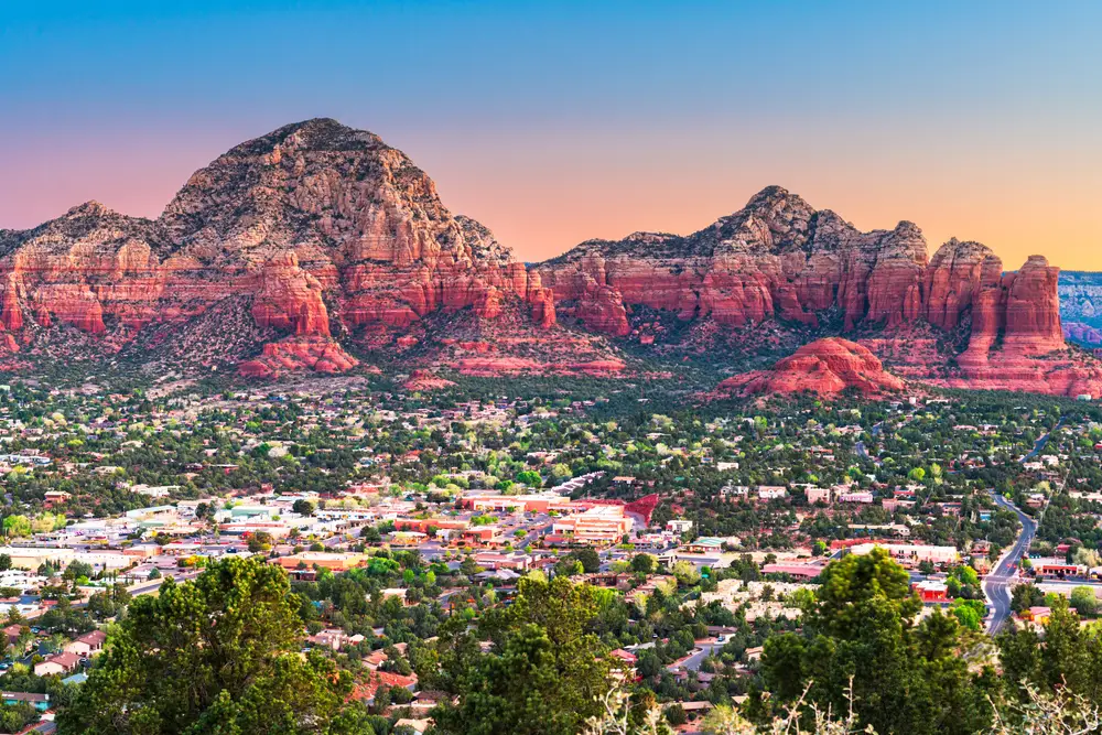 Sunset aerial view of the famous red rocks and overview of the town during the summer to show why you should visit Sedona