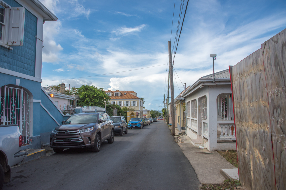 Small blue houses on Christiansted in St. Croix pictured under a semi-cloudy sky for a piece on whether or not St. Croix is safe to visit