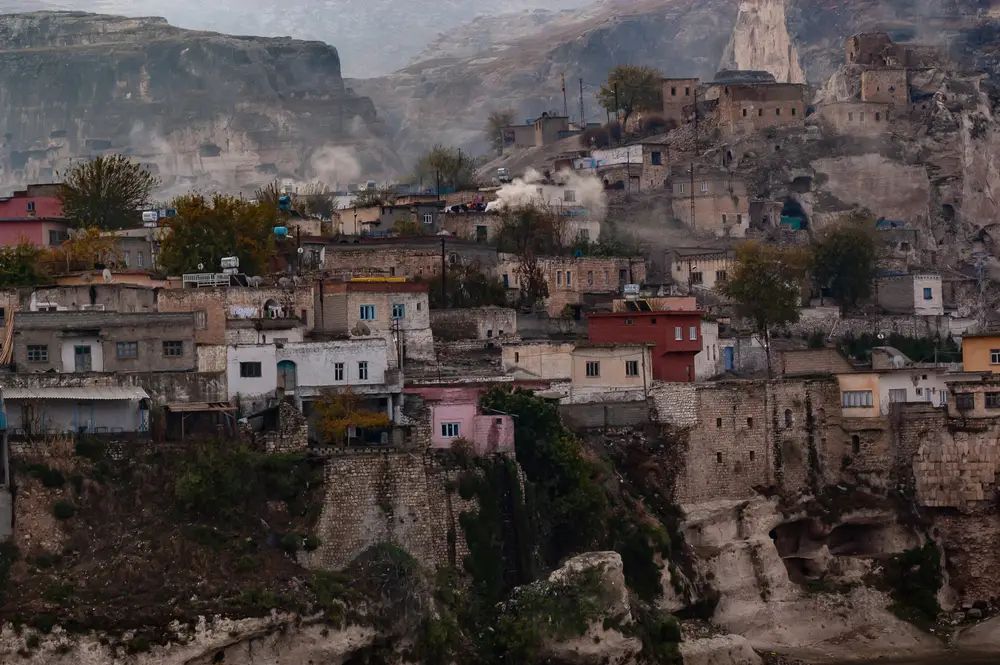 For a piece titled Is Cappadocia Safe to Visit, a cliffside town named Hasankeyf is pictured with a gloomy fog overhead