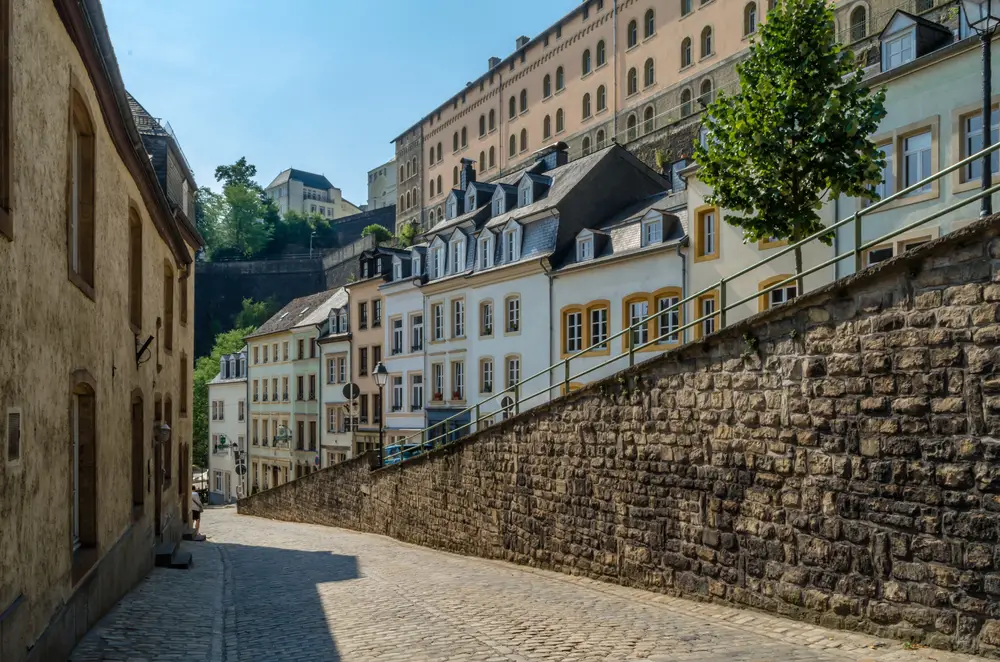 Empty streets of the Grand Duchy pictured during the least busy time to visit Luxembourg with stone walls on either side of the street