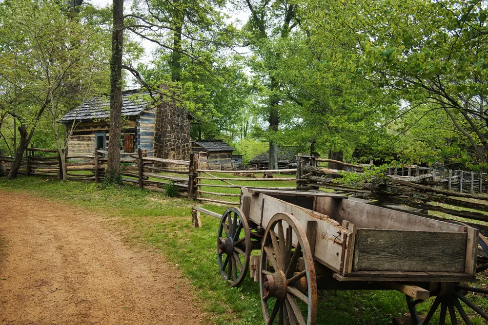 Lincoln State Park in Santa Claus, Indiana with rustic cabin and wagons shown on a summer day