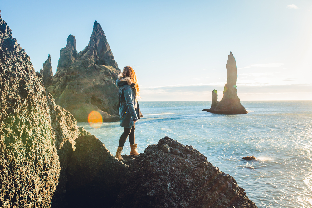 Γυναίκα που στέκεται στην άκρη ενός απότομου βράχου στην Ισλανδία