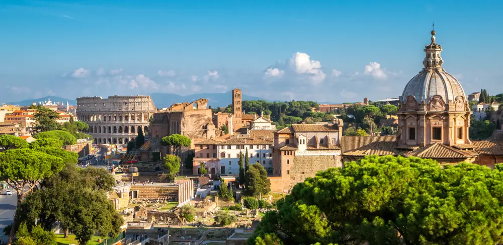 Aerial view of Rome with the Colosseum and Roman Forum in view on a nice day in summer with greenery around the ruins for a list of the top tourism destinations worldwide