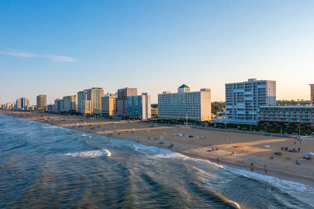 Virginia Beach resorts and hotels along the shore at sunset with waves crashing shows one of the East Coast's best vacation spots