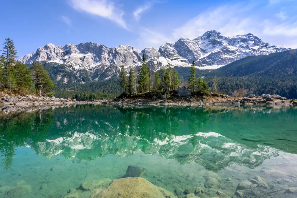 Zugspitze from Eibsee Lake reflecting in the water on a beautiful day for a ranking of the best mountains in Germany