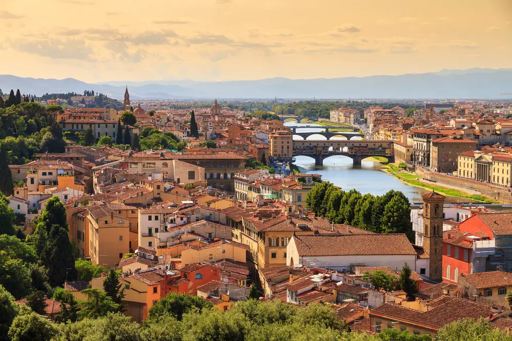 Cityscape view of Florence, Italy with bridges over the Arno River at sunset to show the #1 best city to visit in Europe