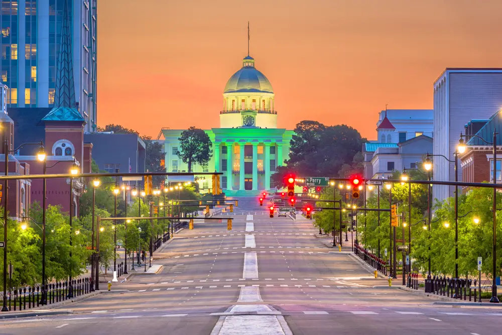 Main street in Montgomery at night with the capitol building in full view and lit up in green for a guide to the best time to visit Alabama