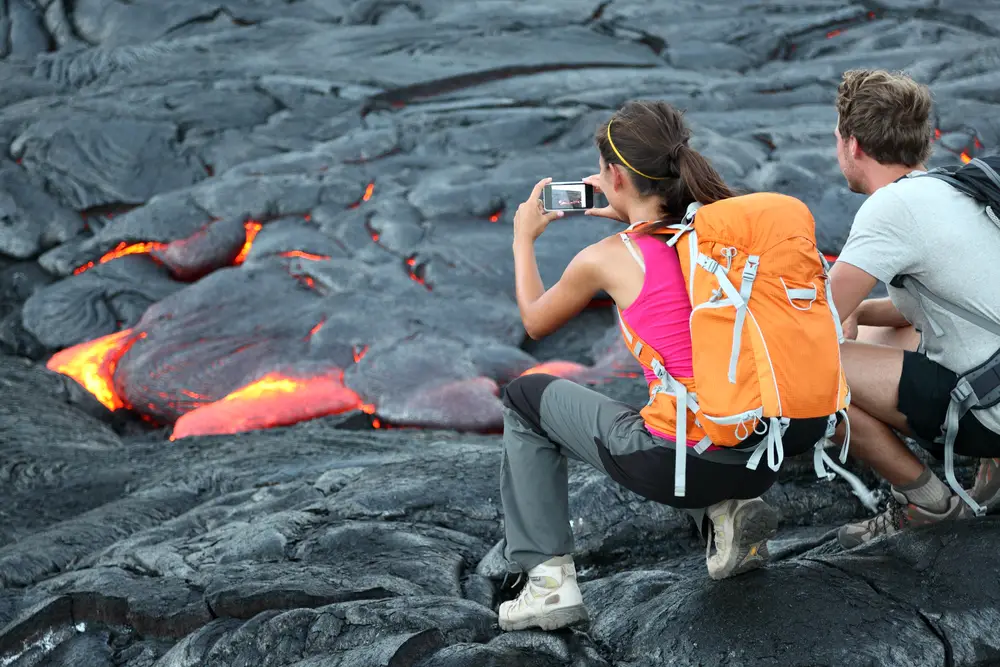 Tourists taking photos of lava in one of the best things to do on the Big Island, Volcanoes National Park