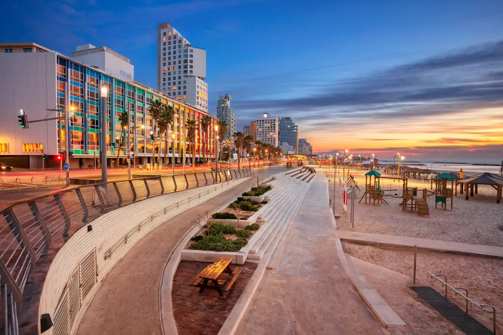 Dusk view of the modern concrete promenade pictured during the best time to visit Tel Aviv, with great weather and blue skies overhead