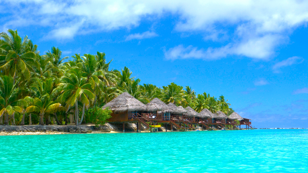 Picturesque view of above-water bungalows on Aitutaki Island, one of the best places to stay in the Cook Islands