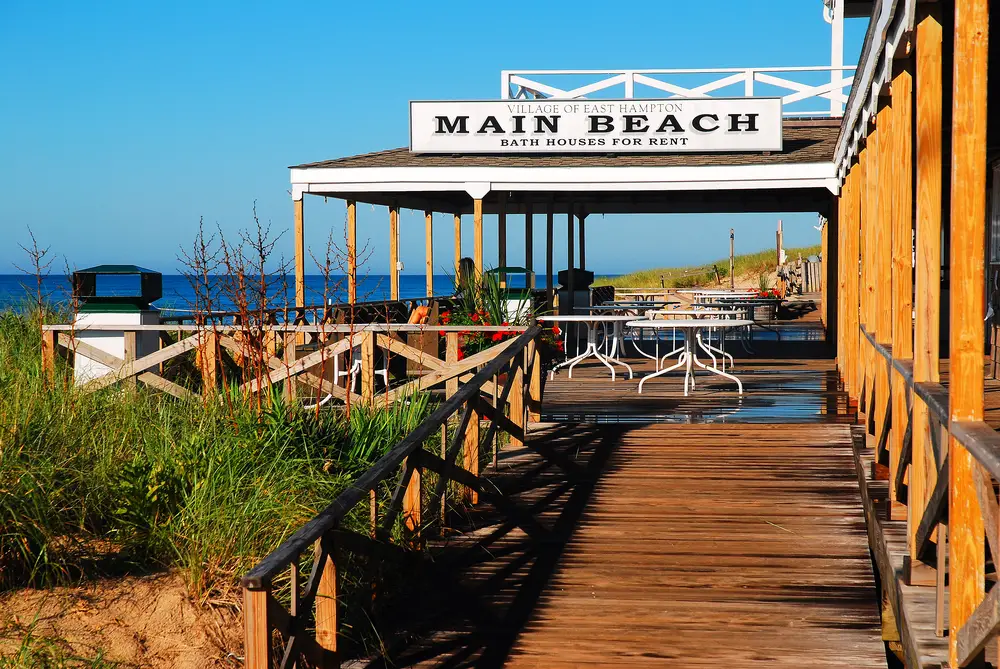 Photo of a beach and restaurant that says Main Beach in East Hampton in July, one of the best overall times to visit the Hamptons