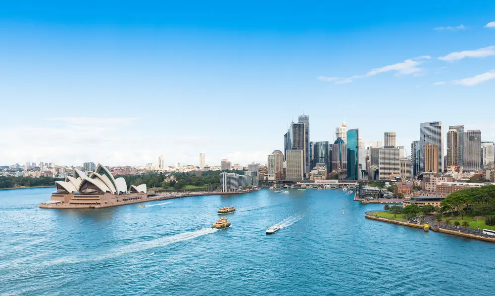 Sydney, Australia is ranked as one of the best places for solo travel, shown here with the Sydney Opera House and Circular Quay on a beautiful day with boats in the water