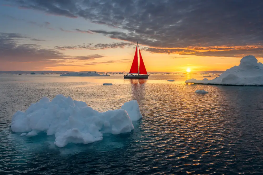 Photo of the sunsetting over Disco Bay as a part for a piece on the average cost of a trip to Greenland