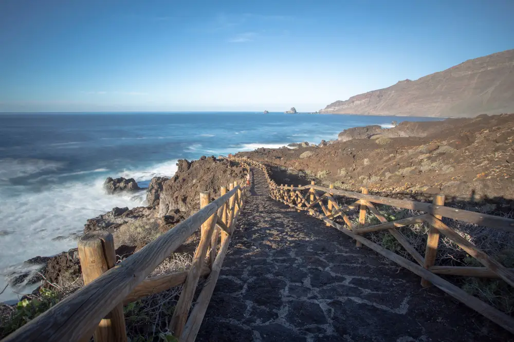 As an image for a guide titled Where to Stay in the Canary Islands, a stone path leading down to the ocean pictured on El Hierro