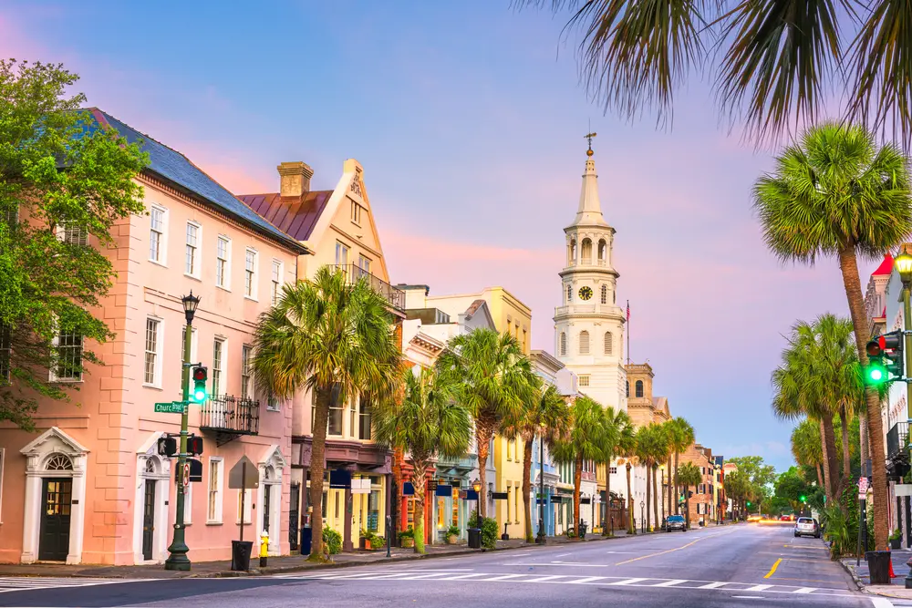 The French Quarter of Charleston downtown at dusk lined with trees and colorful buildings for a list of the top wedding destinations in the US