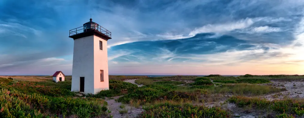 Wood End Lighthouse in Provincetown, Cape Cod ranks on the list of the top wedding places in the US shown with clouds overhead at sunset