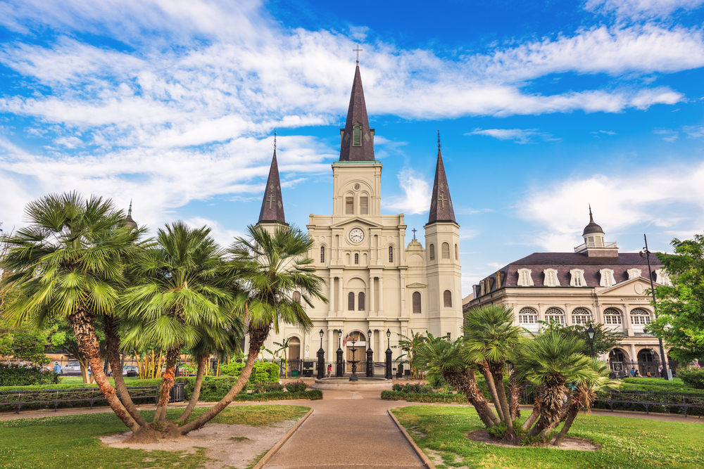 Jackson Square and St. Louis Cathedral shown in New Orleans, LA with palm trees and blue skies for a list of the best wedding destinations in the US