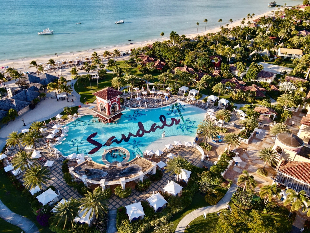 Aerial view on a resort with a large pool that writes 