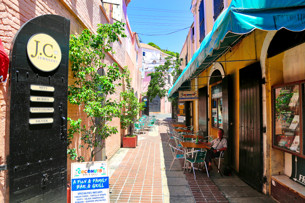 Shopping center in the historic city center of Charlotte Amalie, pictured with its chairs outside of the narrow brick alleyway, on a blue sky day