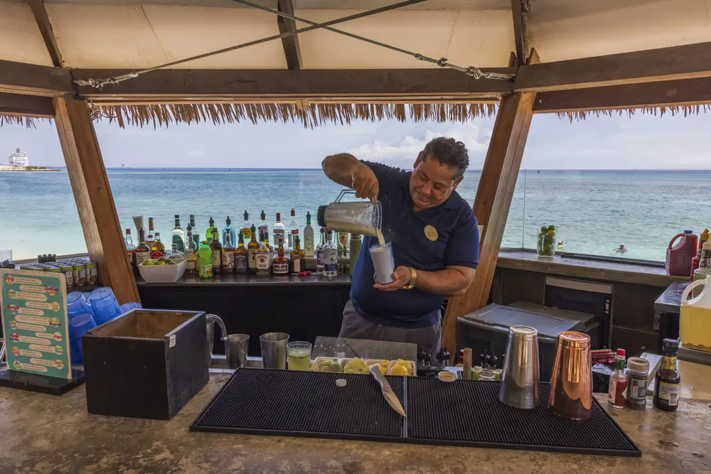 Ένας μπάρμαν ετοιμάζει ένα ποτό σε ένα μπαρ δίπλα στην παραλία. 