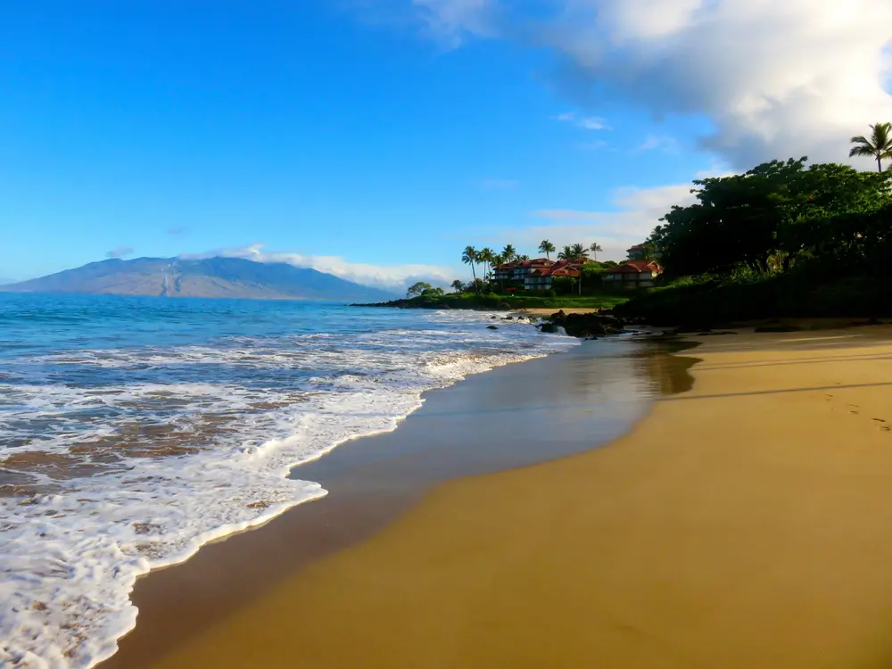 One of the best wedding destinations in the US, Polo Beach Park in Wailea, Maui, shown with mountains in the distance