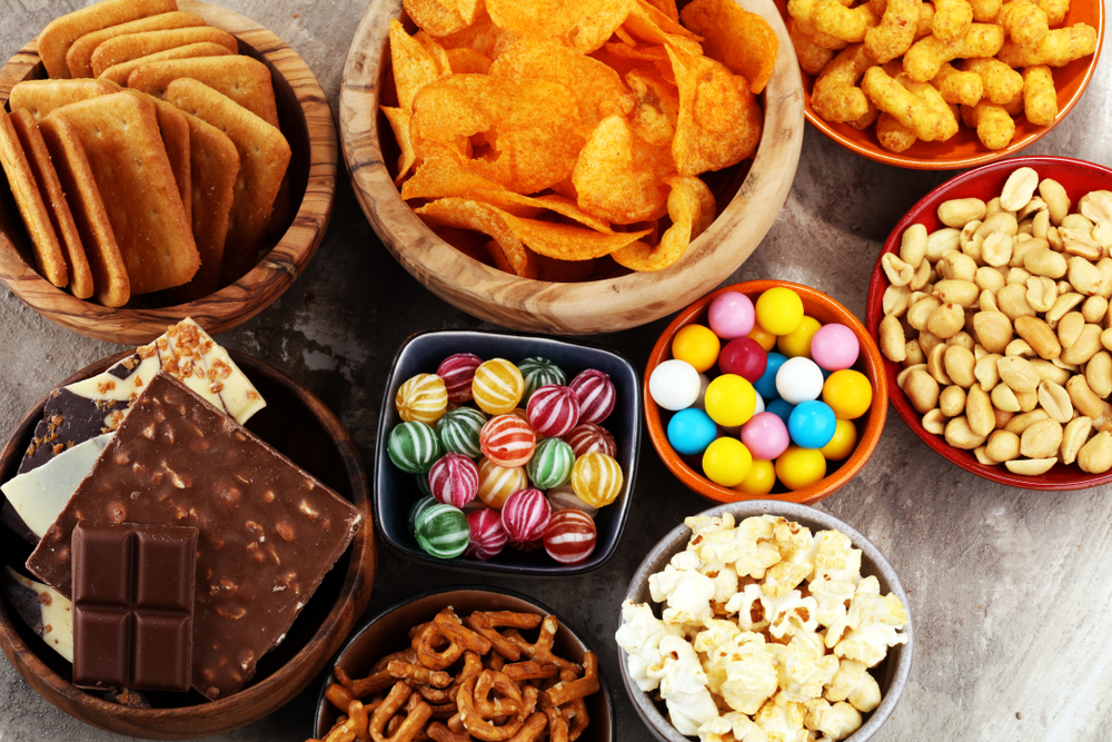 Variety of snack foods salty and sweet arranged in bowls to show which snacks are allowed on a plane