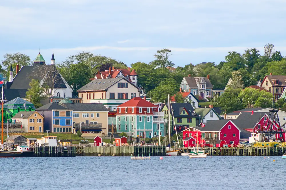 A coastal town with vibrant colored houses and a few small boats on the pier. 