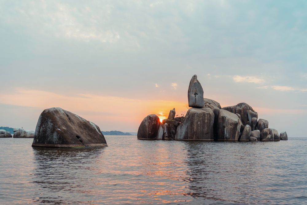 Μεγάλοι βράχοι διακρίνονται στη μέση της θάλασσας κατά τη δύση του ηλίου.