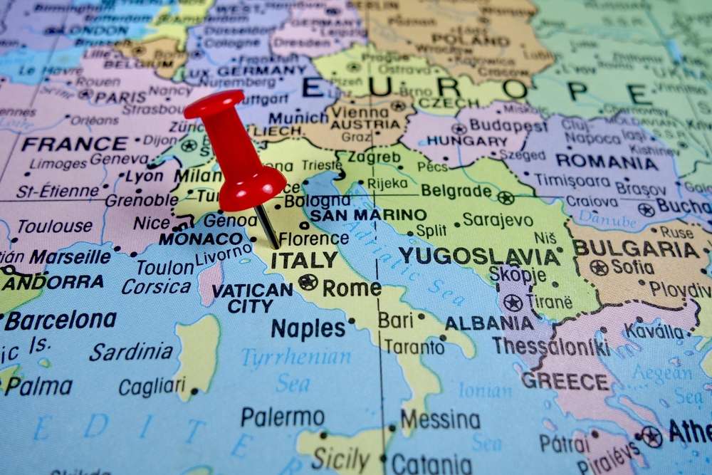 Μια κόκκινη καρφίτσα καρφωμένη στη χερσαία περιοχή της Ιταλίας στο χάρτη. 