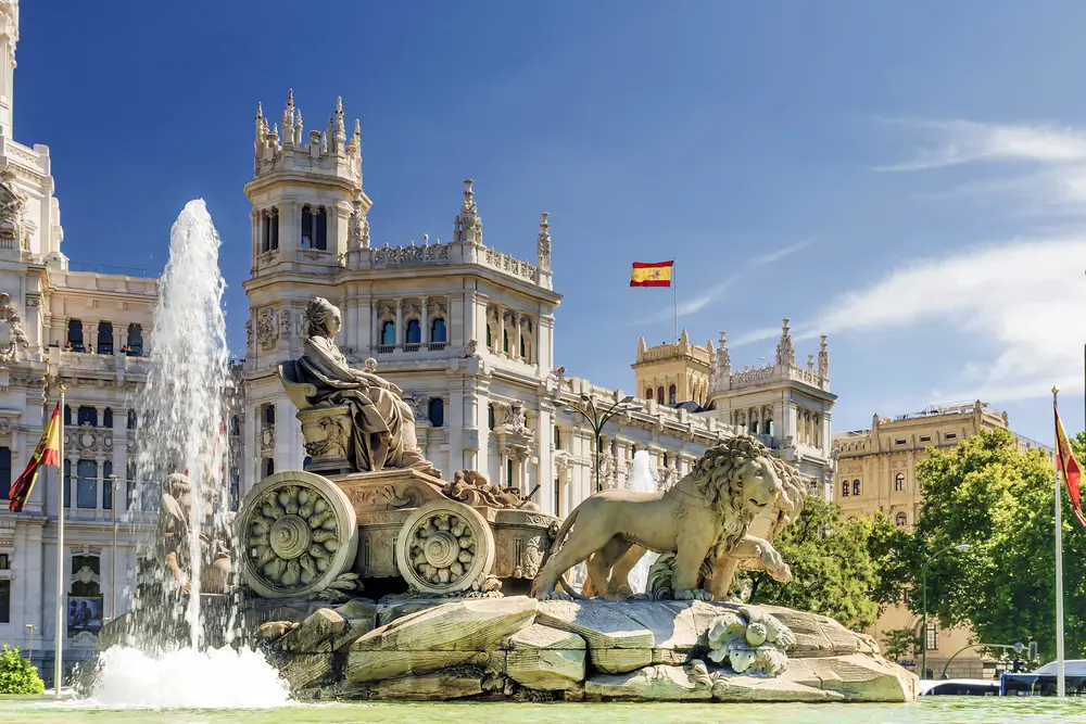 Madrid, Spain shown with a view of the Fountain of Cibeles flowing on a nice day for a section describing the highlights of visiting Spain over Portugal