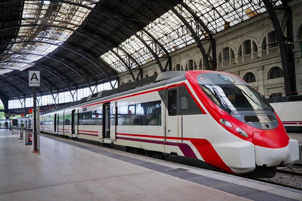 Σύγχρονο τρένο υψηλής ταχύτητας με κόκκινα γραφικά στη Βαρκελώνη, Ισπανία για έναν οδηγό που περιγράφει λεπτομερώς βήμα προς βήμα πώς να ταξιδέψετε στην Ευρώπη με το τρένο
