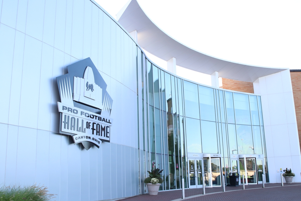 Μια μοντέρνα κατασκευή που έχει μια πινακίδα μπροστά από το Pro Football Hall of Fame Canton.