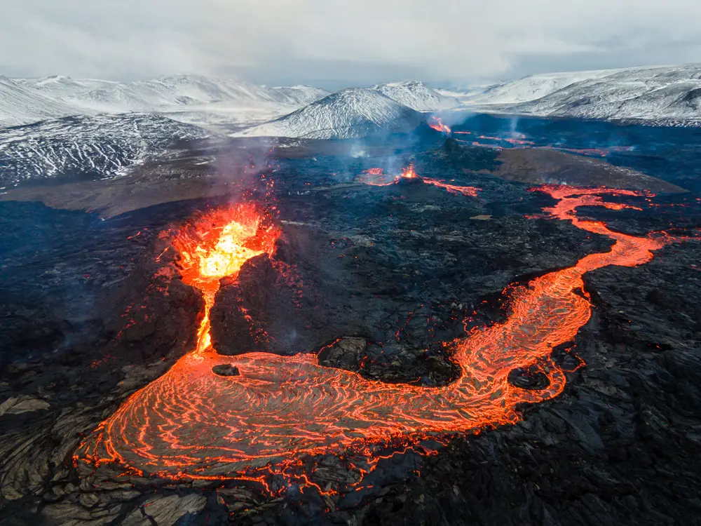 View of an active volcano spewing lava, Mount Fagradalsfjall, for a guide exploring how long is a flight to Iceland from the US with and without stops