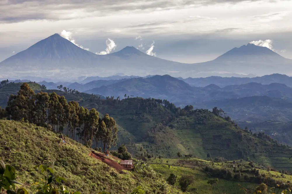 Αεροφωτογραφία μιας ορεινής περιοχής όπου τρία ψηλά βουνά διακρίνονται στο βάθος.